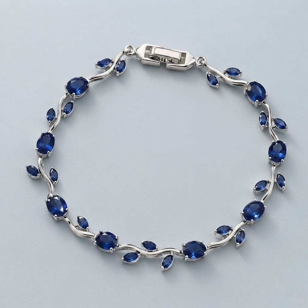 Silver vine-style tulip leaf bracelet with oval and marquise deep blue crystals on light gray background - Snap Mart Pakistan