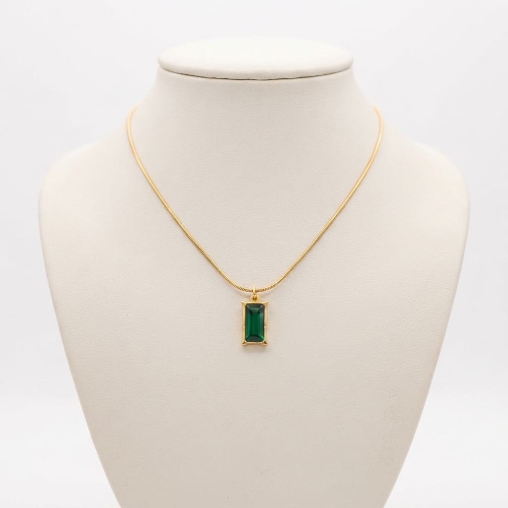 Emerald-cut green rectangular stone pendant on a fine gold snake chain displayed on a cream jewelry bust - Snap Mart Pakistan