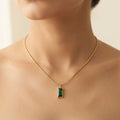 Emerald-cut green rectangular gemstone pendant on a fine gold snake chain necklace worn around a model's neck - Snap Mart Pakistan