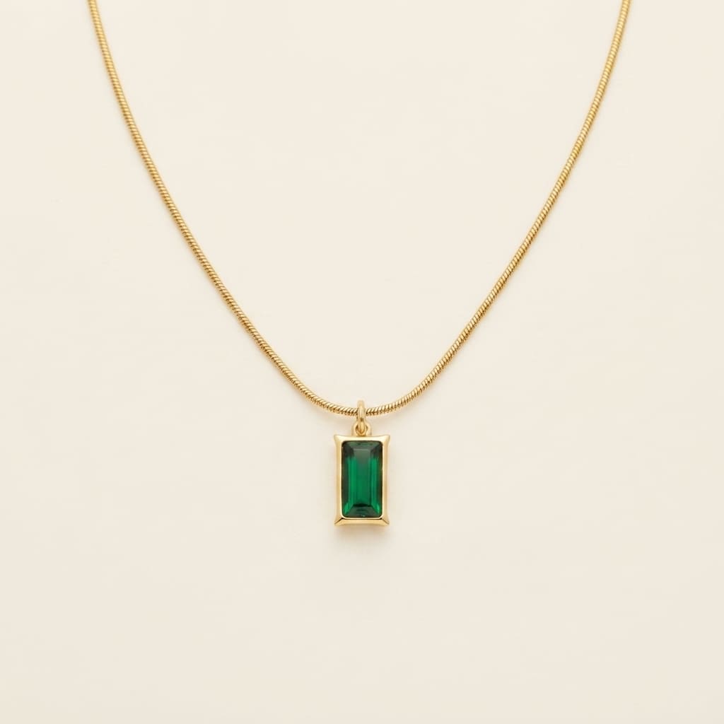 Emerald-cut green rectangular stone pendant on a fine gold snake chain displayed on a cream jewelry bust - Snap Mart Pakistan