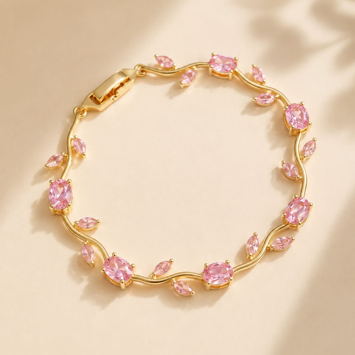 Gold vine-style tulip leaf bracelet with oval and marquise pink crystals on warm beige background - Snap Mart Pakistan
