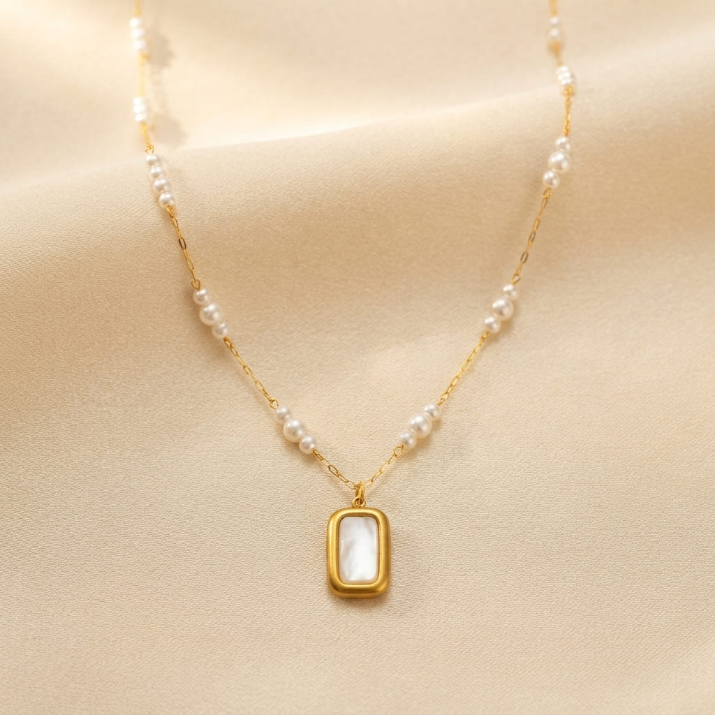 Golden rectangular pearl pendant necklace with mother of pearl inlay on beige fabric background - Snap Mart Jewelry Pakistan