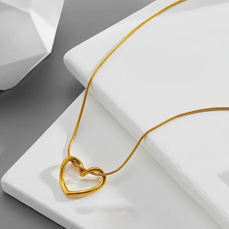Twisted gold open heart pendant necklace on snake chain resting on white display stand - Snap Mart Jewelry Pakistan