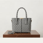 Grey monogram print faux leather handbag with top handles and a matching shoulder strap on a wooden table.
