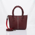 Maroon synthetic leather handbag with a braided top handle and center stripe, shown with a detached shoulder strap on a white background