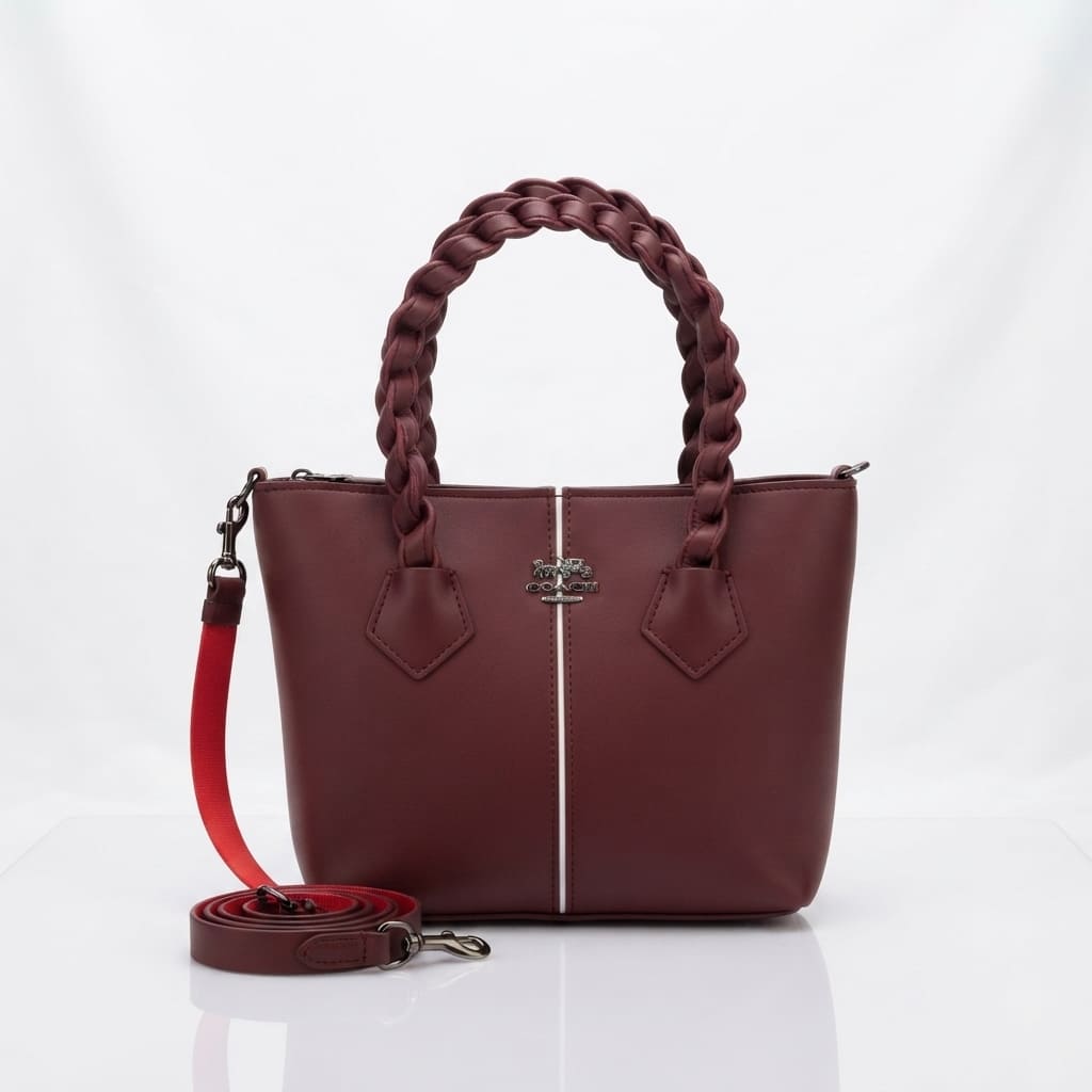 Maroon synthetic leather handbag with a braided top handle and center stripe, shown with a detached shoulder strap on a white background