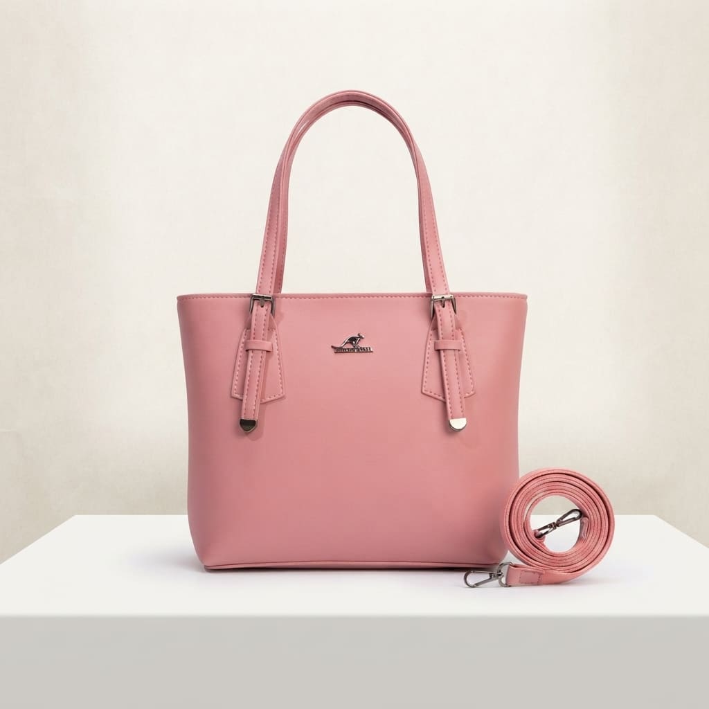 Pink faux leather handbag with buckle details on handles and a detachable shoulder strap on a white surface.