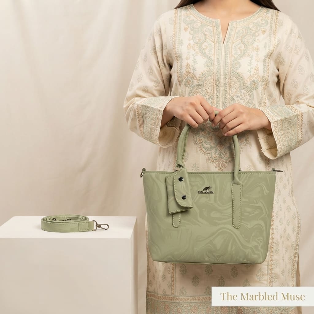 Close-up of the light green marbled handbag showing the attached mini pouch and top handles.