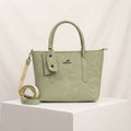 Sage green faux leather handbag with a marble pattern, top handles, mini pouch, and an adjustable strap on a white background.