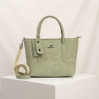 Sage green faux leather handbag with a marble pattern, top handles, mini pouch, and an adjustable strap on a white background.