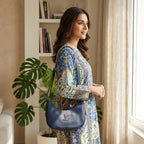 South Asian woman carrying navy blue leather shoulder purse over patterned dress